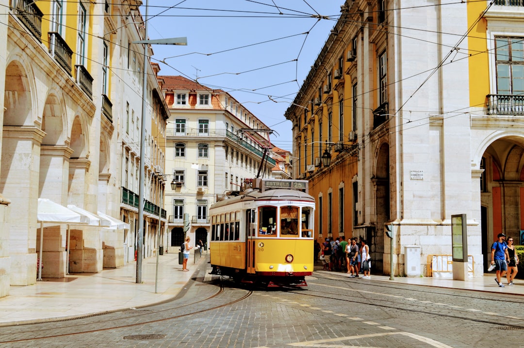 Tramway jaune emblématique de Lisbonne dans une rue pavée du centre historique